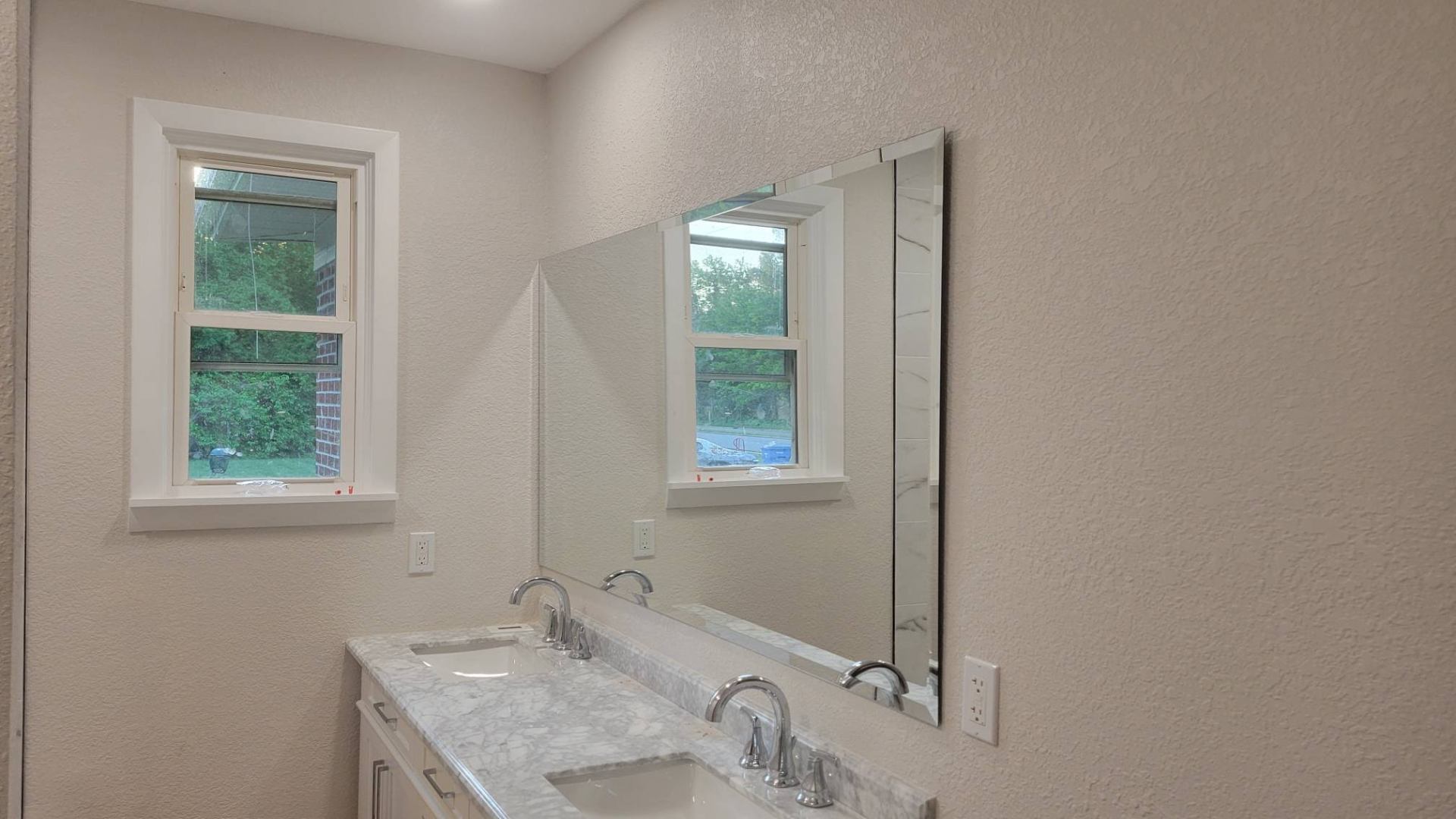 Large bathroom mirror installed above a double vanity in Deep Creek, Chesapeake by Blanchard Home Services