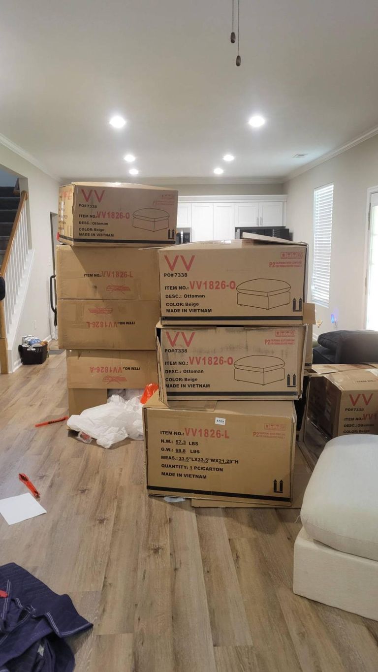 Stacked sectional furniture boxes before assembly by Blanchard Home Services